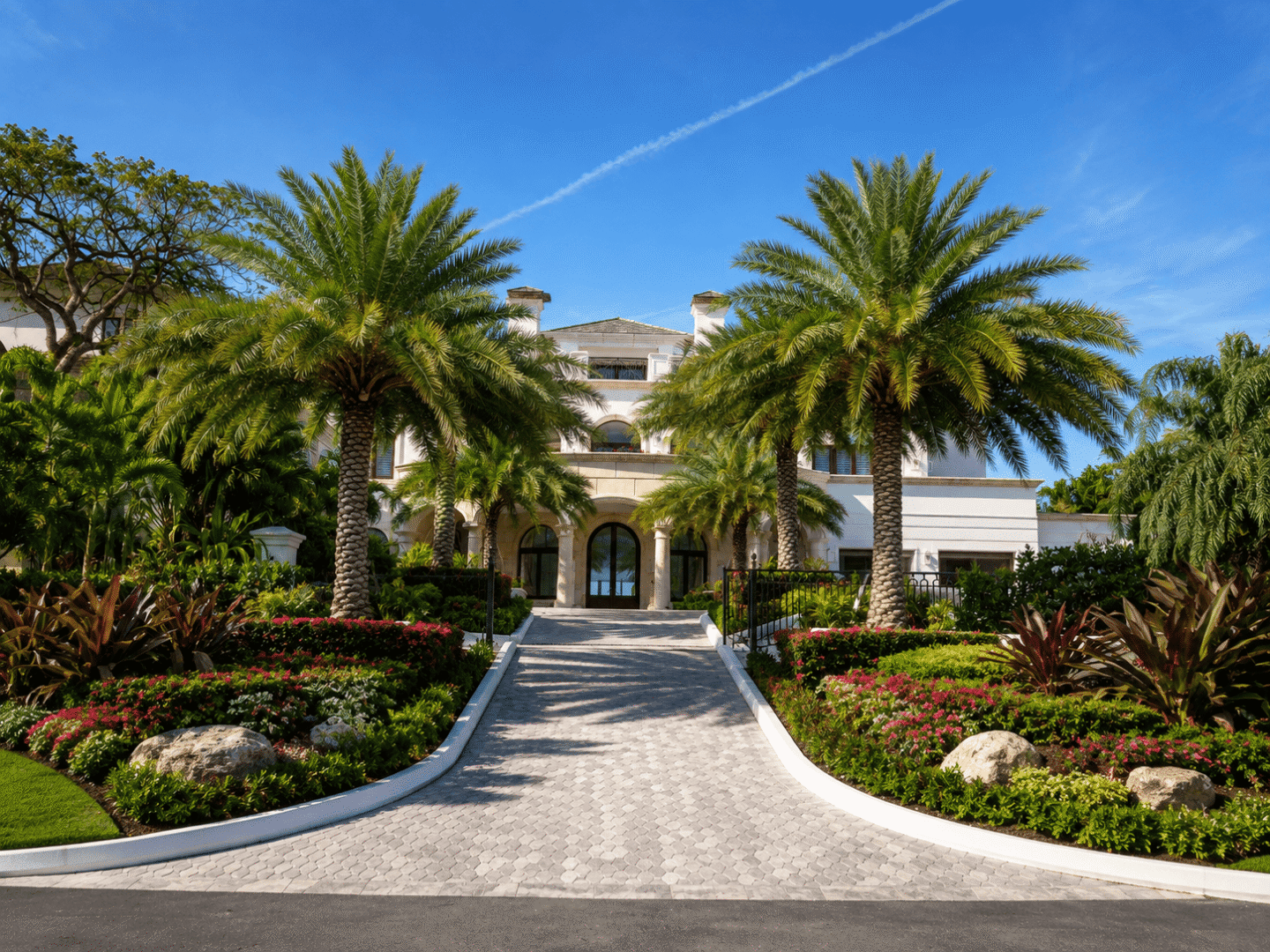 Elegant beachfront villa in the Bahamas with lush landscaping and palm trees.