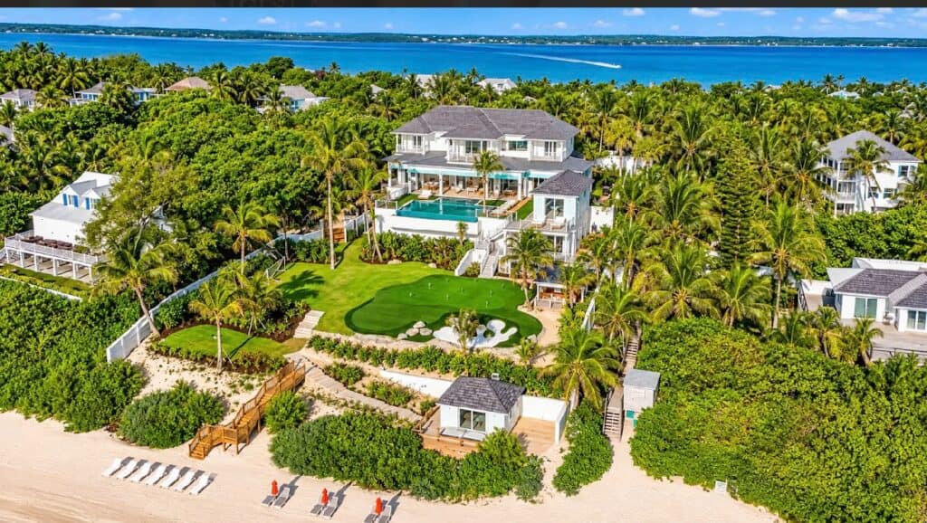 Elegant beachfront villa with pool and lush gardens in Bahamas.