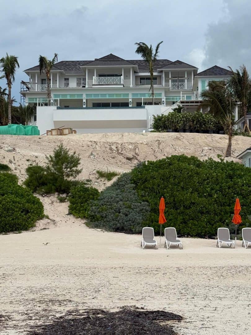 Elegant beachfront villa with ocean views and palm trees in Bahamas.