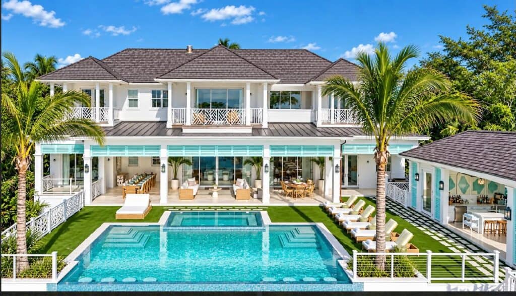 Elegant Bahamas vacation home with pool, palm trees, and outdoor lounge area.