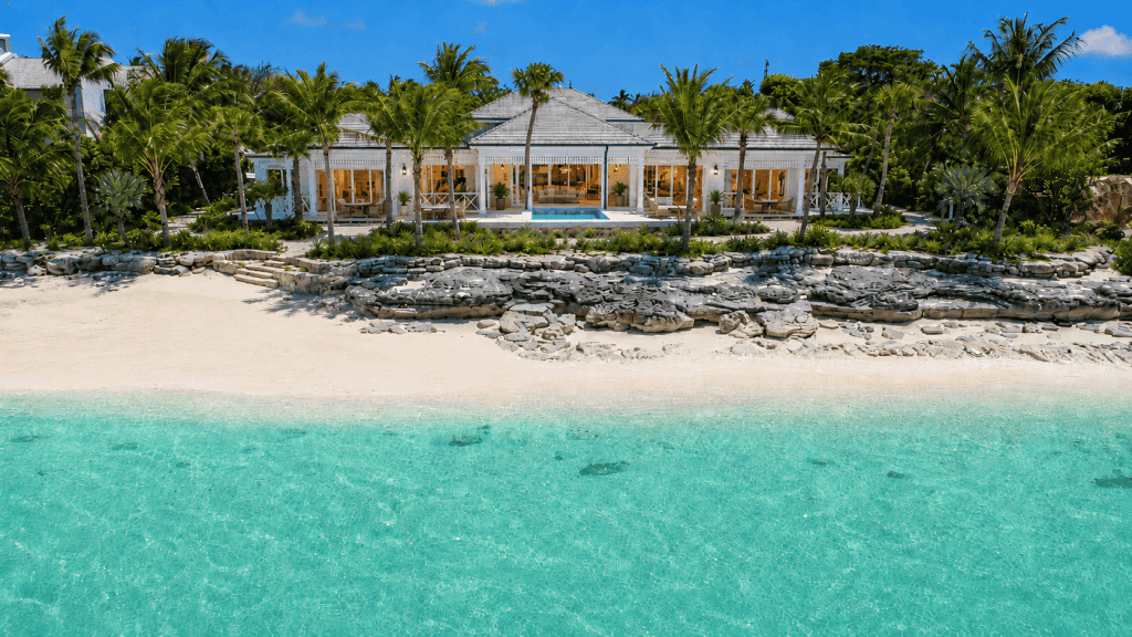 Elegant beachfront villa with pool and tropical landscaping in Bahamas.