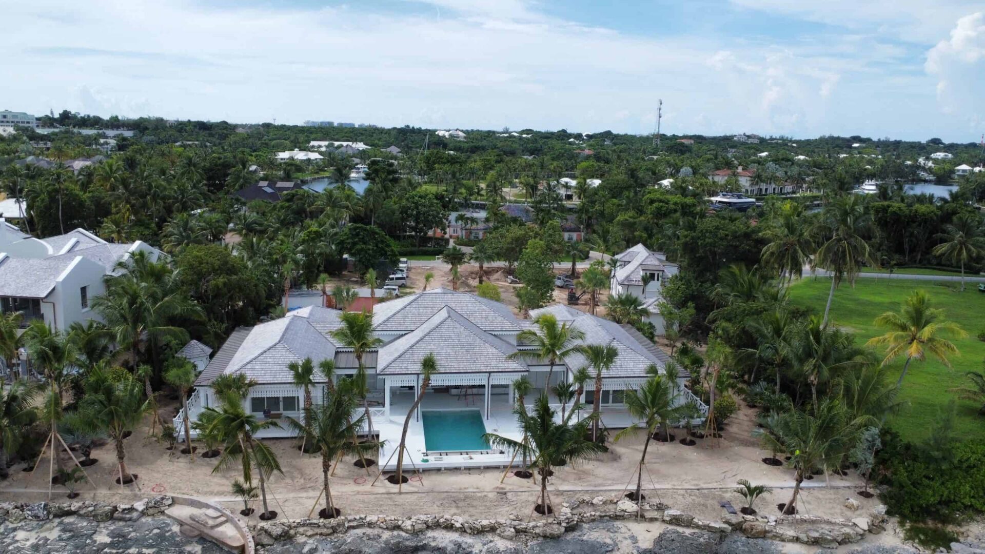 Aerial view of a luxury Bahamas vacation home with a pool and tropical landscaping.