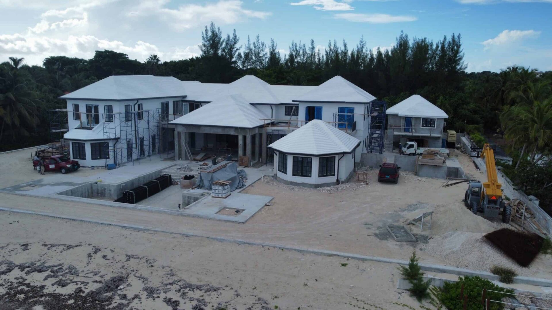 Under construction luxury beachfront villa with multiple levels and modern design.