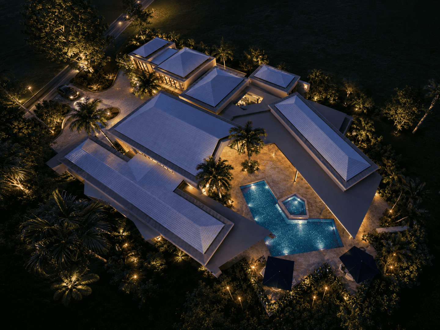 Aerial view of a luxury Bahamas villa with pool and tropical landscaping at night.