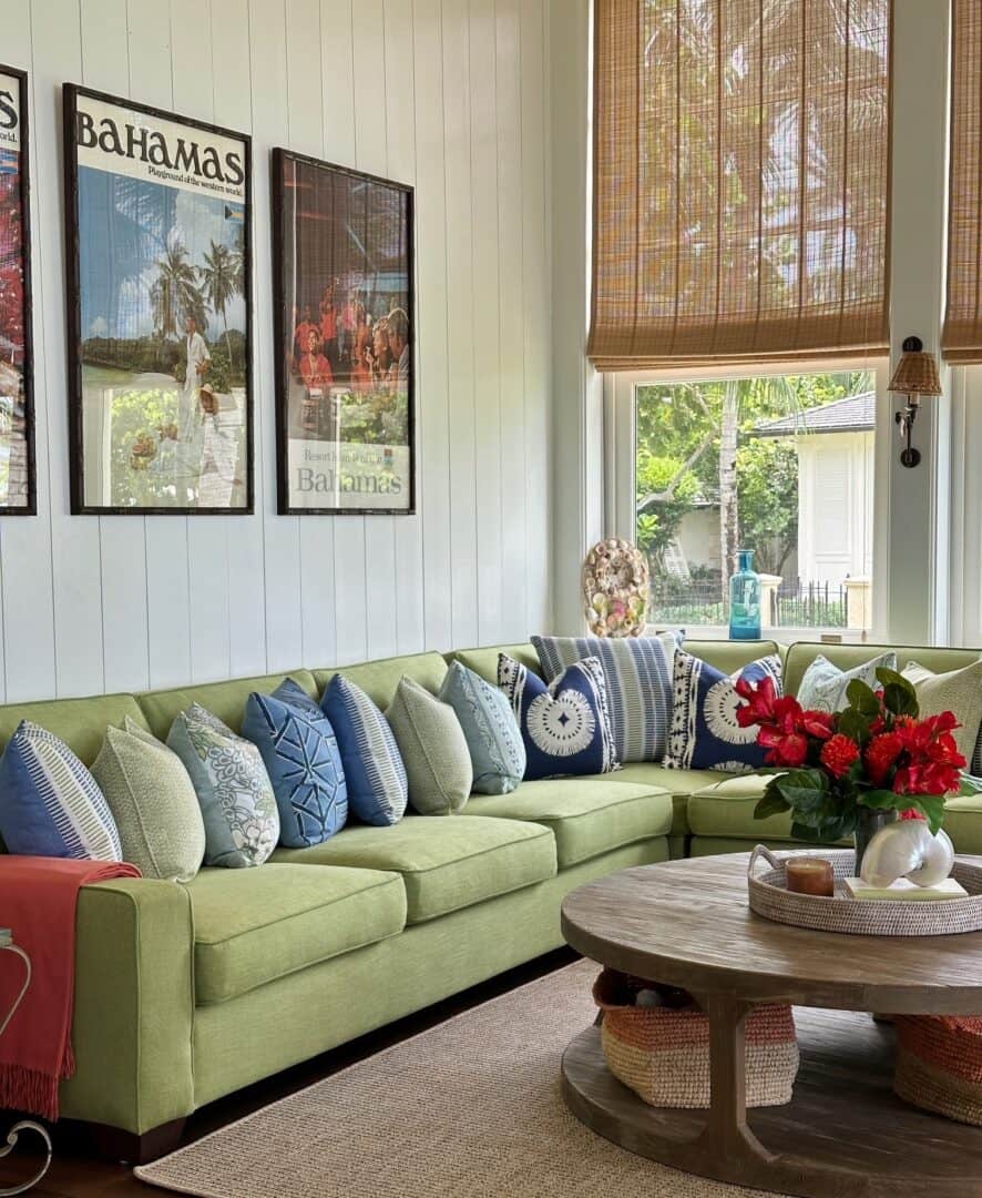 Cozy living room with green sofa, tropical decor, and Bahamas posters.