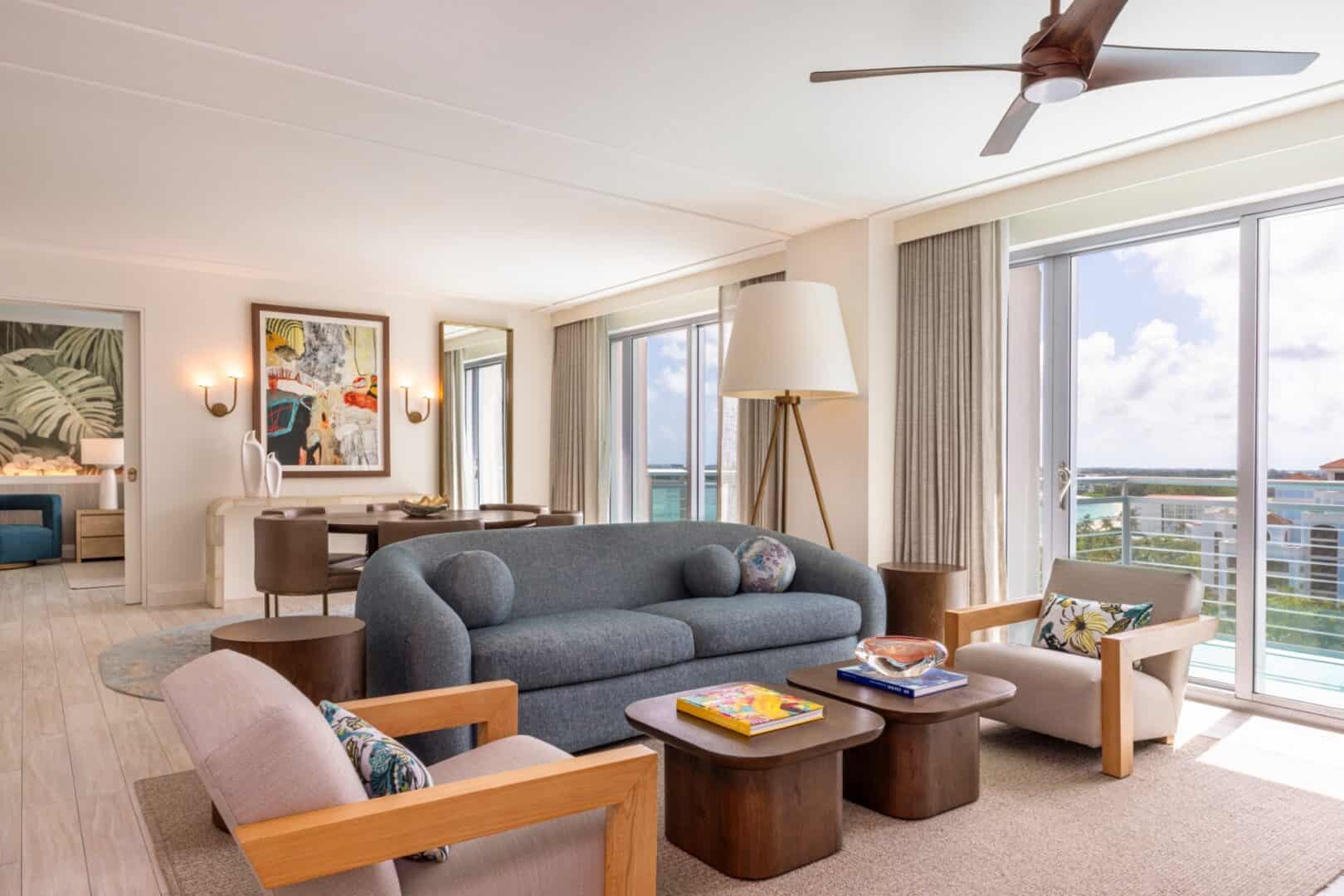 Modern living room with large windows, stylish furniture, and ocean view.