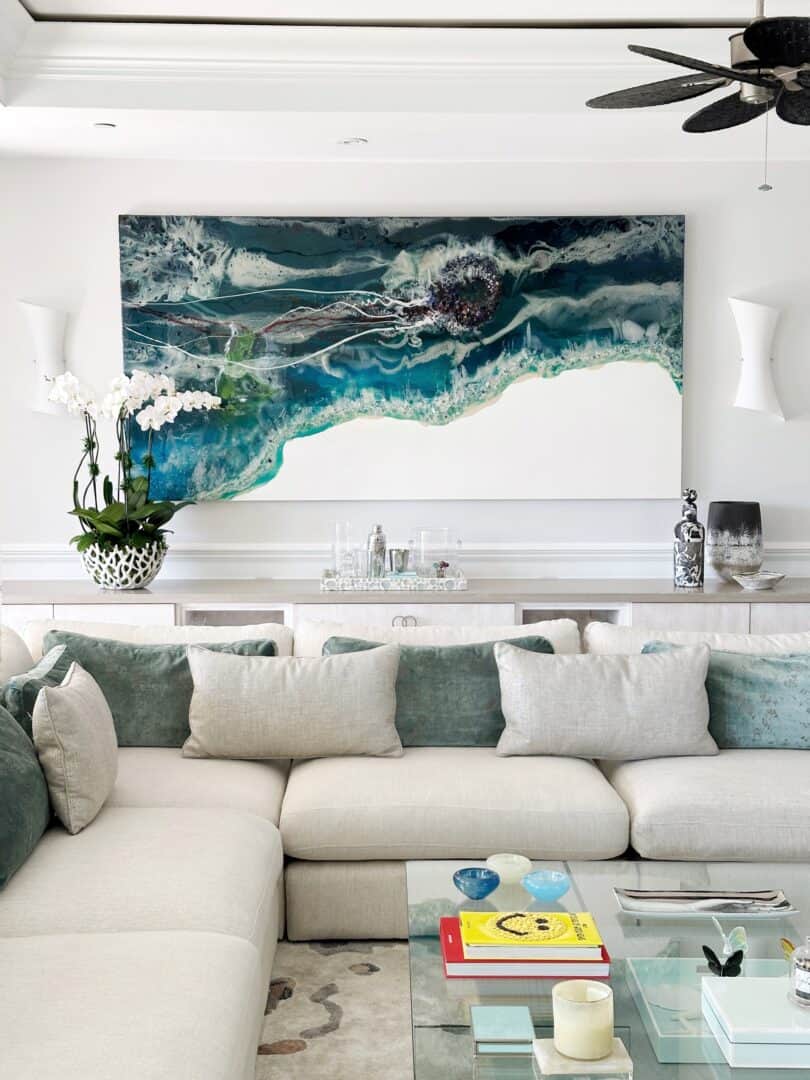 Modern living room with abstract ocean-themed wall art and neutral decor.