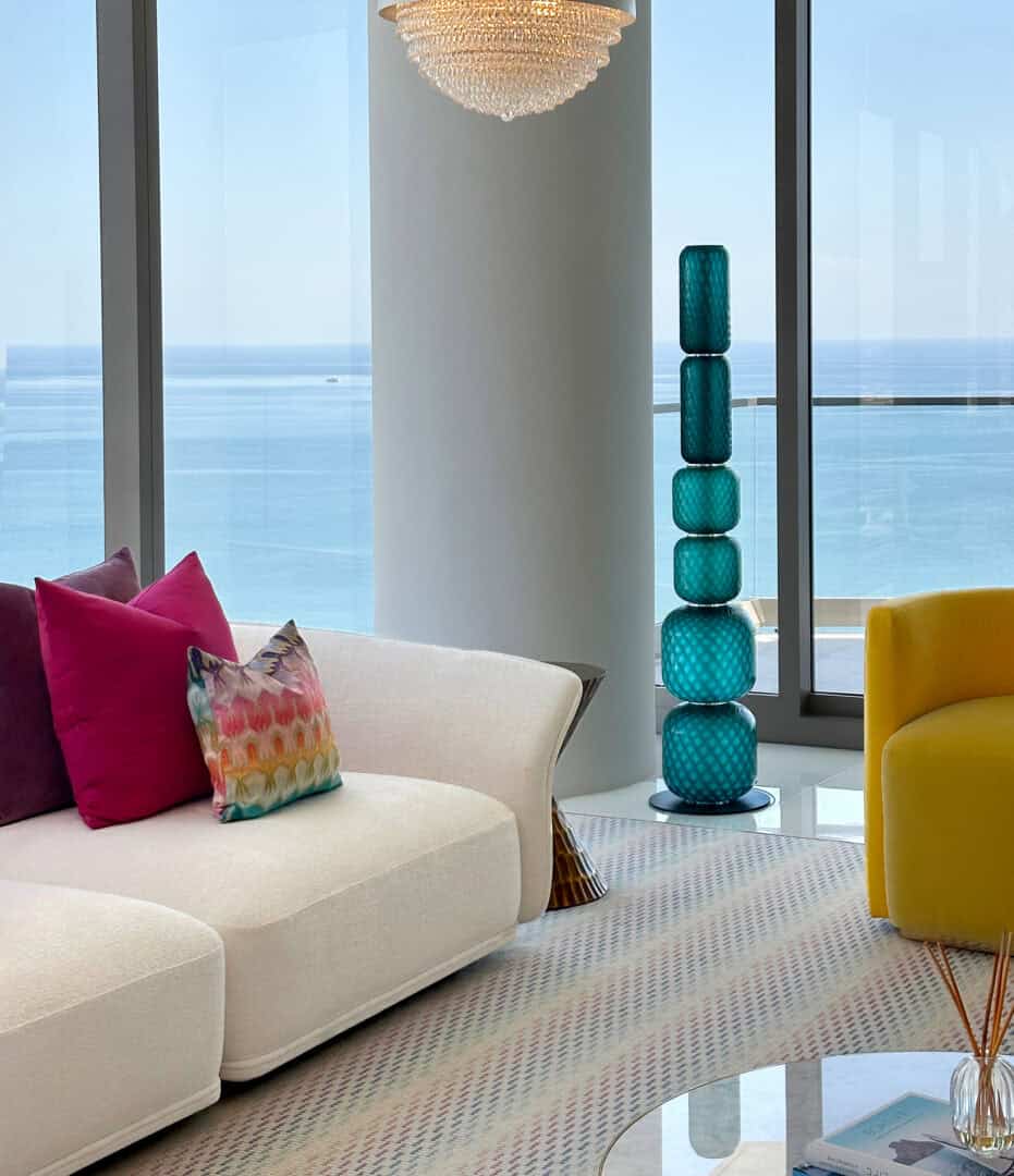 Modern living room with ocean view, colorful cushions, and stylish decor.