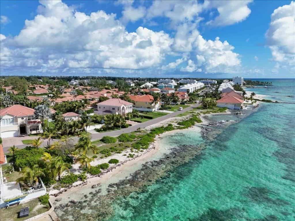 Aerial view of Treasure Cove private residence with beach and turquoise waters.